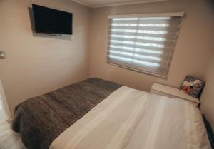 a bedroom with a bed and a flat screen tv at casa ikigai in Curacautín +1 photo