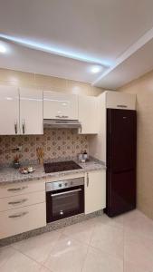a kitchen with white cabinets and a black refrigerator at Apartamento moderno con wifi y parking gratis in Tangier