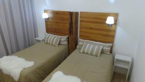 two beds sitting next to each other in a room at DH Country House in Évora