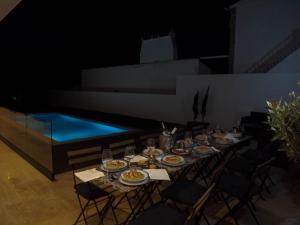 a table with plates of food next to a swimming pool at DH Country House in Évora