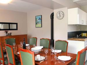 a dining room with a table and a clock on the wall at Gîte chaleureux avec poêle à bois et jardin à Lavoine - FR-1-489-332 in Lavoine