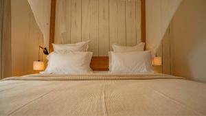 a bed with white pillows on top of it at Villa Mire - Domaine de la maison blanche in Terre-de-Haut +2 photos