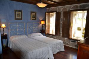 a bedroom with a bed with a blue wall at Palacio de Barreiro in Crecíente