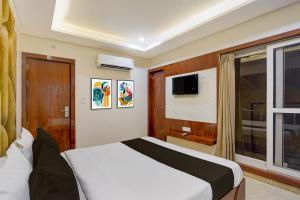 a bedroom with a bed and a tv and a window at Townhouse Oak Railway Junction Kota Formerly Hotel Crosslane in Nānta +22 photos