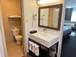 a bathroom with a sink and a toilet and a mirror at Quality Inn in West Des Moines