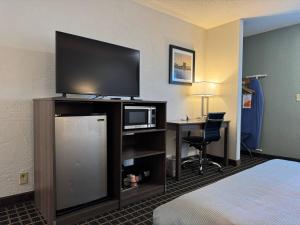 a hotel room with a bed and a flat screen tv at Quality Inn in West Des Moines +11 photos