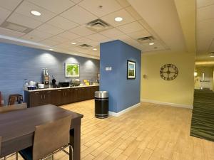 a large lobby with a dining room and a kitchen at Sleep Inn & Suites Altoona North in Altoona