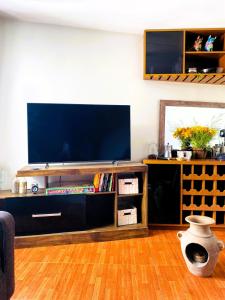 a living room with a large television on a entertainment center at Casa Ñusta- Living culture & regenerative tourism in Cusco