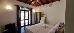a bedroom with a large bed and a window at Villa Red, Battaramulla in Sri Jayewardenepura Kotte