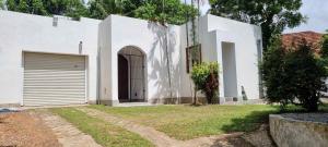 a white house with a door and a garage at Villa Red, Battaramulla in Sri Jayewardenepura Kotte