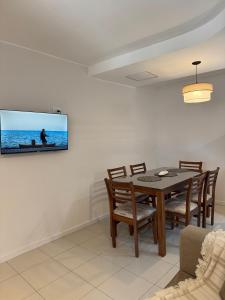 a dining room with a table and a tv on the wall at corazón de Maipú in Maipú