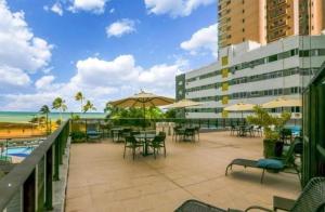 レシフェにあるFlat com vista panorâmica do mar em Boa Viagem, Recifeの海の景色を望むパティオ(テーブル、パラソル付)