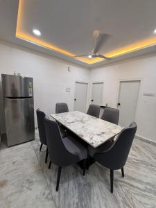 einen Konferenzraum mit einem Tisch und Stühlen sowie einem Kühlschrank in der Unterkunft Blue moon in Hyderabad