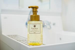 鹿儿岛YASAKAHotel的水槽上放一瓶液状肥皂