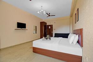 a bedroom with a large white bed and a tv at Townhouse Classio Suites in Shirdi