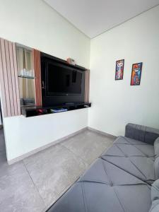 ein Wohnzimmer mit einem Flachbildfernseher an der Wand in der Unterkunft Casa 3 Fronteiras in Foz do Iguaçu