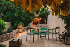 eine Terrasse mit Stühlen, einem Tisch und einem Pool in der Unterkunft Casa De Cortes in Mérida