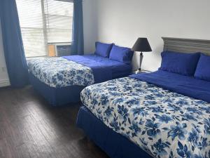 een slaapkamer met 2 bedden met blauwe en witte lakens bij So sweet so stylish in Elizabeth