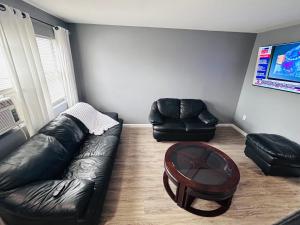 een woonkamer met een leren bank en een tafel bij So sweet so stylish in Elizabeth