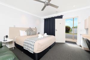 a bedroom with a bed with a ceiling fan at Boggabri Motel in Boggabri