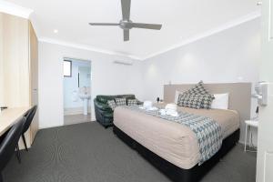 a bedroom with a bed and a black leather couch at Boggabri Motel in Boggabri