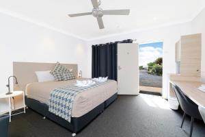 a bedroom with a bed and a ceiling fan at Boggabri Motel in Boggabri