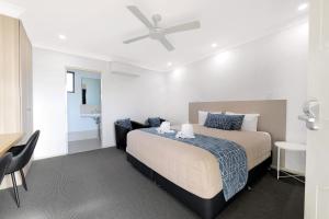 a bedroom with a bed and a desk and a chair at Boggabri Motel in Boggabri