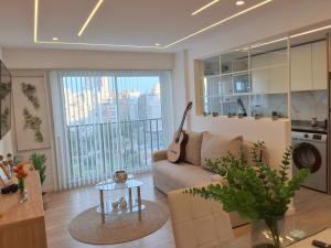 a living room with a couch and a guitar at Vista y confort - Cerca de todo in Mar del Plata