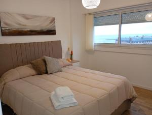 a bedroom with a large bed with a large window at Vista y confort - Cerca de todo in Mar del Plata