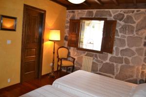 a bedroom with a bed and a stone wall at Palacio de Barreiro in Crecíente +12 photos