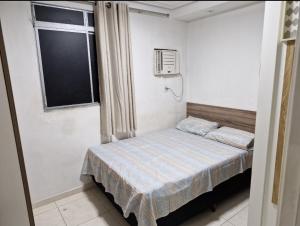 a small bedroom with a bed and a window at Apartamento de 3 quartos para COP 30 in Ananindeua