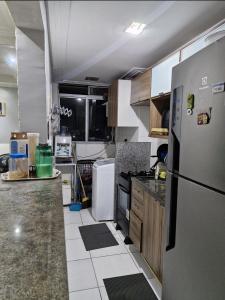 a kitchen with a refrigerator and a counter top at Apartamento de 3 quartos para COP 30 in Ananindeua