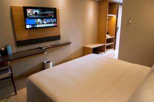 パルにあるKhas Palu Hotelのベッドと薄型テレビがあるホテルの部屋 +14枚の写真