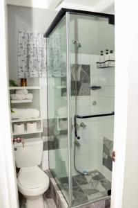 a bathroom with a toilet and a glass shower at Nyla's Charmed Oasis in Portmore +25 photos