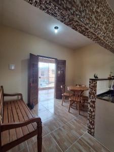 ein Raum mit einem Tisch und Stühlen und einer Holzbank in der Unterkunft Casa aconchegante em Nossa Senhora do Ó, Porto de Galinhas!!! in Ipojuca