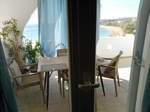 a table and chairs in a room with a view of the ocean at Logaras Seaview Apartment in Logaras