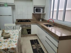 una cocina con fregadero y estufa horno superior en Casa em Indaiatuba, en Indaiatuba