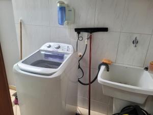 Una lavadora en un baño al lado de una bañera. en Casa em Indaiatuba, en Indaiatuba