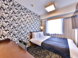 a hotel room with a bed and a patterned wall at APA Hotel Tsukiji Ekiminami in Tokyo