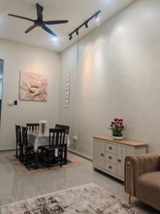 a living room with a dining table and a ceiling fan at Seri Indah Homestay Bandar Baru Kuala Lipis in Kuala Lipis