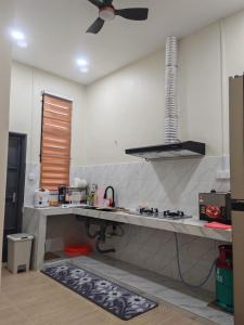 a kitchen with a counter and a stove top oven at Seri Indah Homestay Bandar Baru Kuala Lipis in Kuala Lipis +6 photos