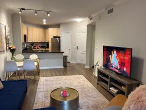 a living room with a couch and a tv on a wall at Spacious 1bdrm apartment 10 mins to Cedars-Sinai by car FREE Parking, King bed in Los Angeles