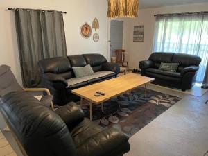 a living room with leather furniture and a coffee table at Fuaamotu Airport Overnight Stay and Catch Your Flight ! in Fua‘amotu