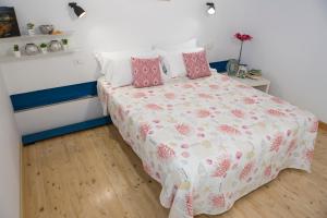 Dormitorio pequeño con cama con almohadas rosas en Guest House del Conte en Fondi