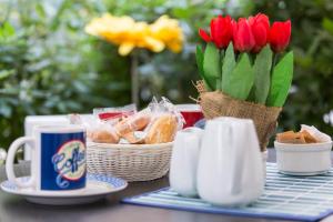 uma mesa com tulipas vermelhas e uma chávena de café em Guest House del Conte em Fondi