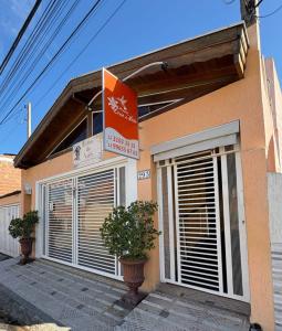 un bâtiment avec deux usines devant lui dans l'établissement Pousada Lirio do Vale, à Cachoeira Paulista