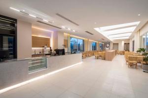 a lobby with a restaurant with tables and chairs at Xutang (Yang Zhou) hot spring Boutique Hotel&Resorts in Jiangdu