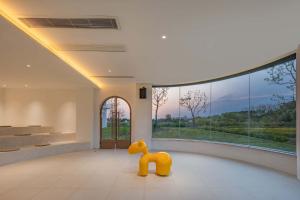 a yellow dog statue in a room with a large window at Xutang (Yang Zhou) hot spring Boutique Hotel&Resorts in Jiangdu