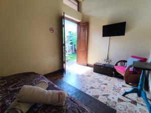 a bedroom with a bed and a tv and a door at Doeloerkoe Homestay in Solo