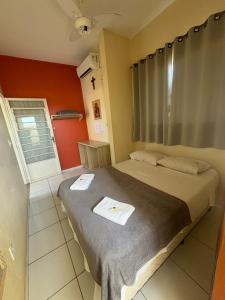 une chambre avec un lit avec deux serviettes dessus dans l'établissement Pousada Lirio do Vale, à Cachoeira Paulista 33 autres photos